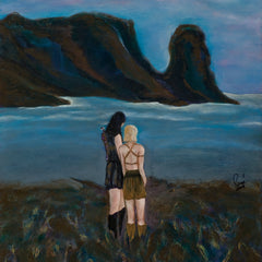 Two people standing on a grassy hill overlooking a body of water with mountains in the background.